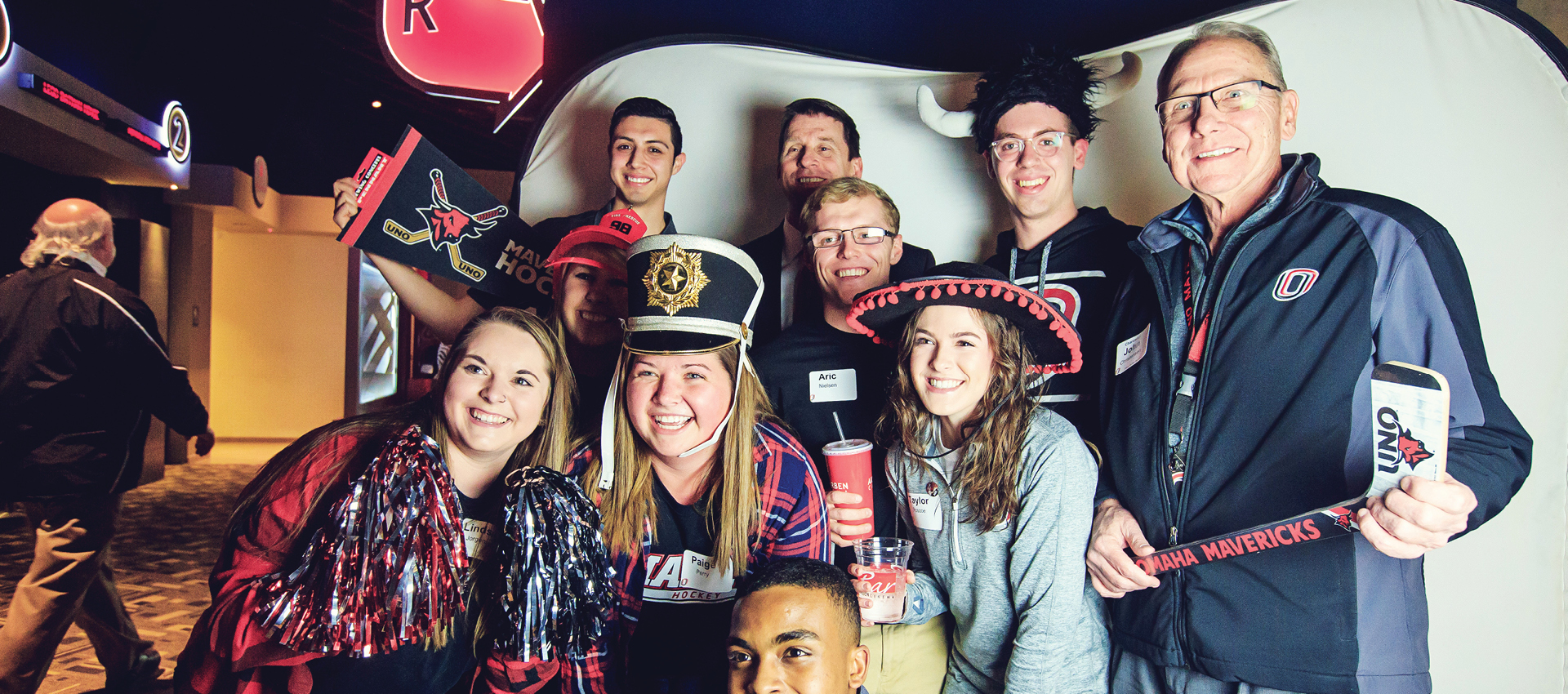 Group of students and chancellor standing together smiling in UNO gear.
