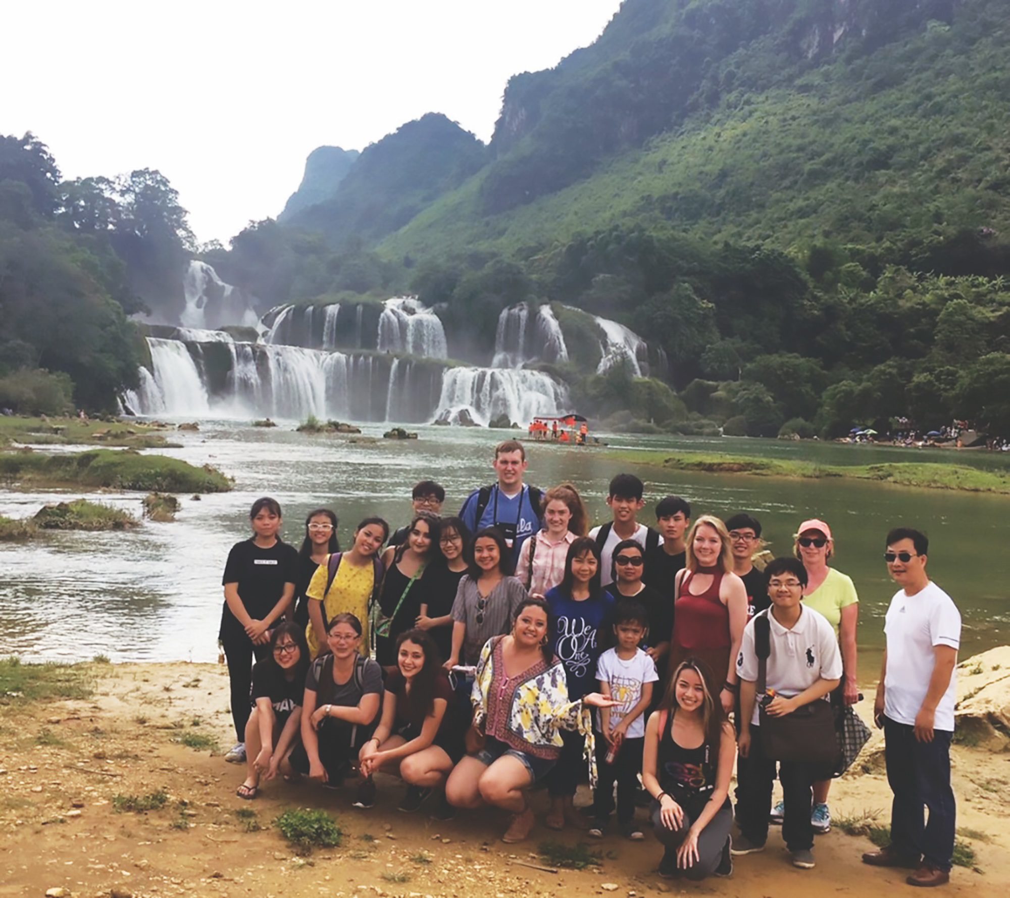 Group photo of college students and professors in front of the Bản Giốc Falls on the Quây Sơn River that straddle the international border between China and Vietnam