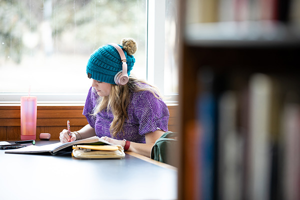 a uno student studies at a table in criss library