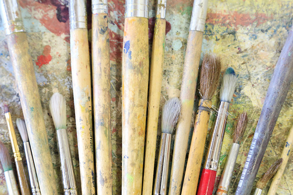 paintbrushes laying on a colorful canvas