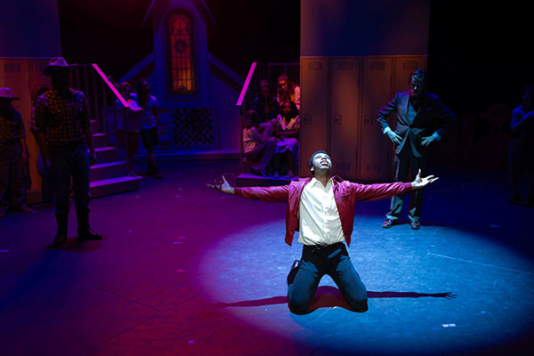 students perform in a production of “Footloose” in uno's strauss performing arts center