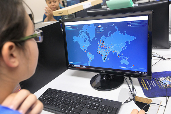 a student looks at a computer screen showing targeted places on a world map