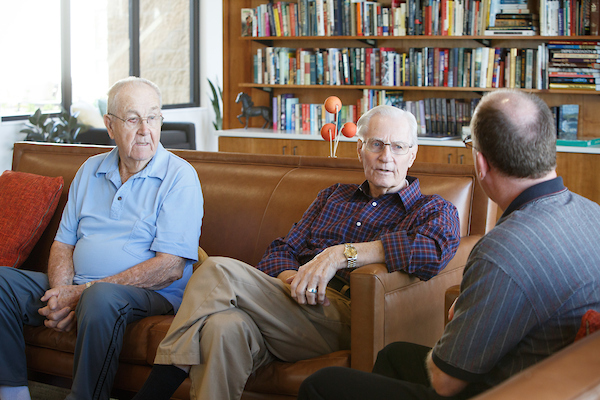 old men sit on a couch and talk