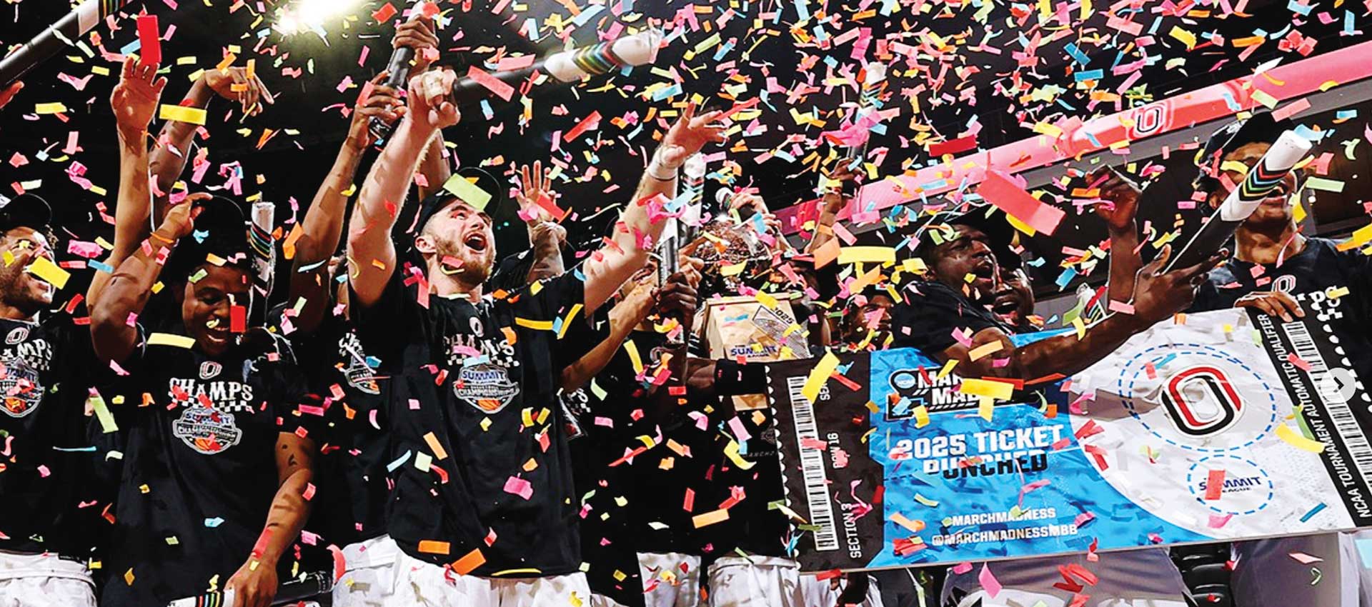 basketball players covered in paper confetti celebrating a game win