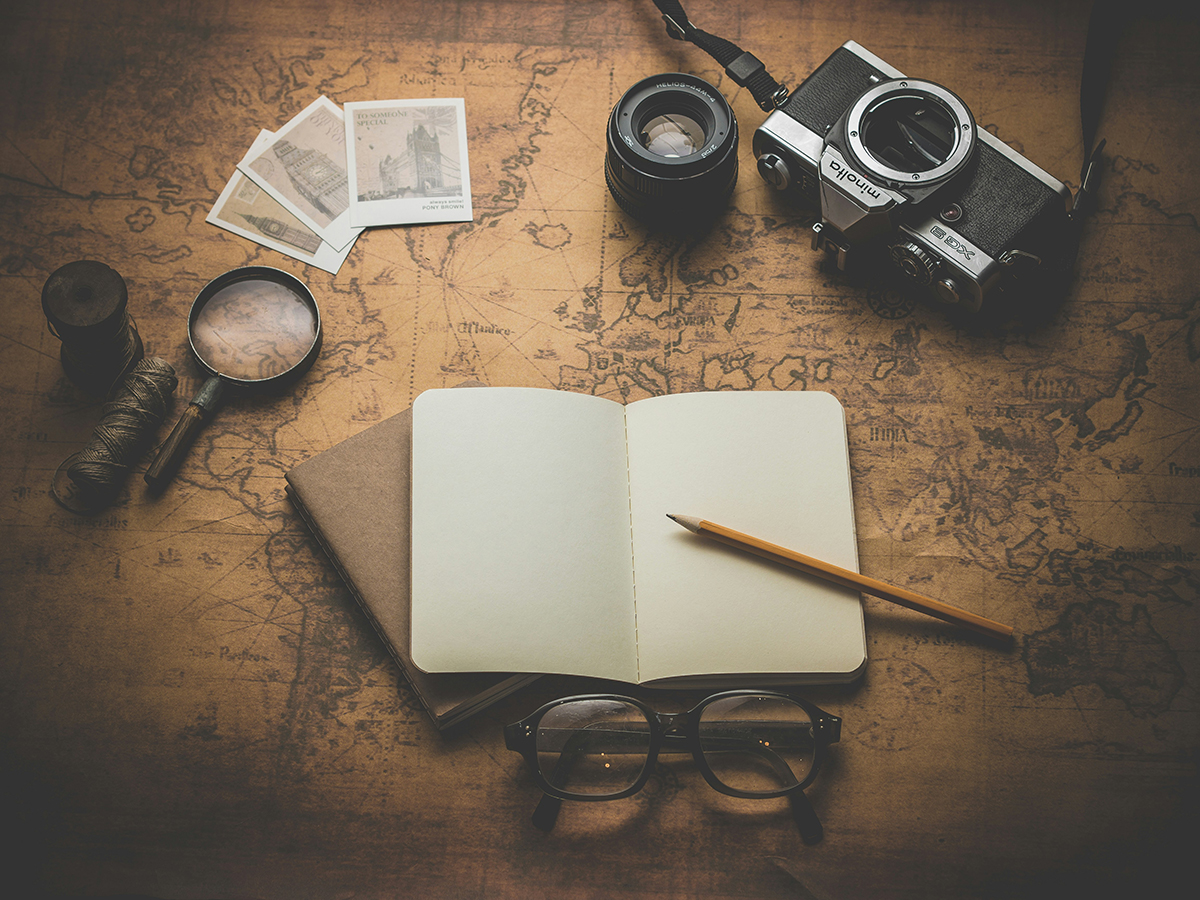 Notebook, old map, camera, photos, and magnifying glasses and 