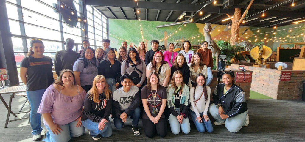 A group picture of UNO's MavMentor's at a training event hosted at Prehistoric Putt Putt.