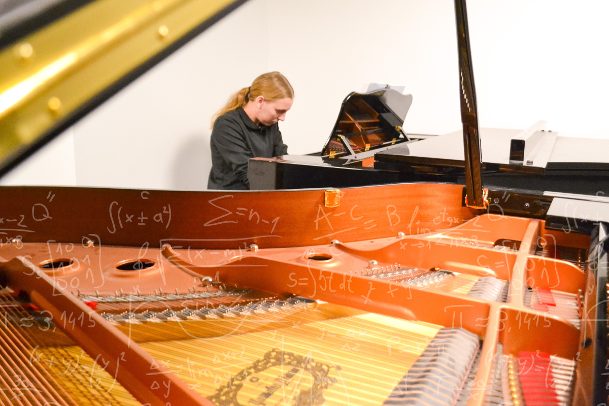 Natalie McNamara plays the piano in a practice room in Strauss. Over the image is an overlay of mathematic formulas. 