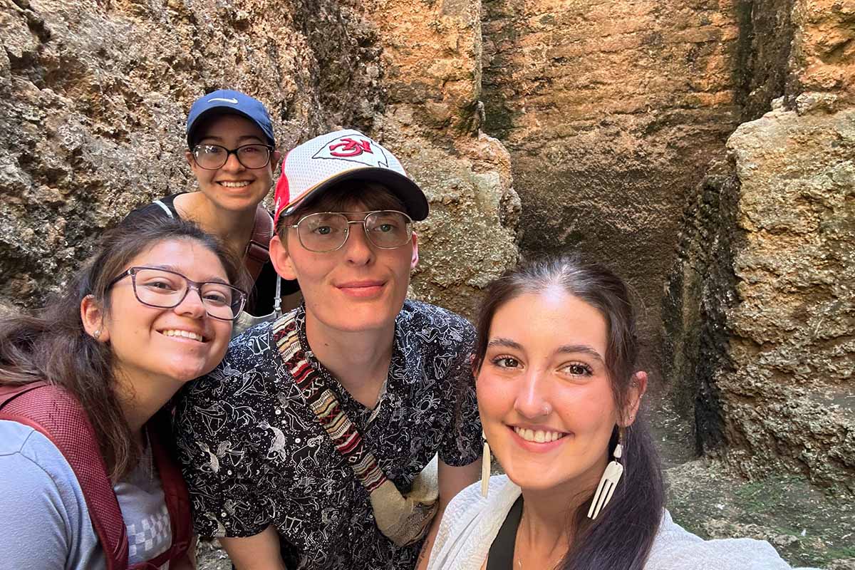 A group of people pose for a photo in front of a rocky canyon