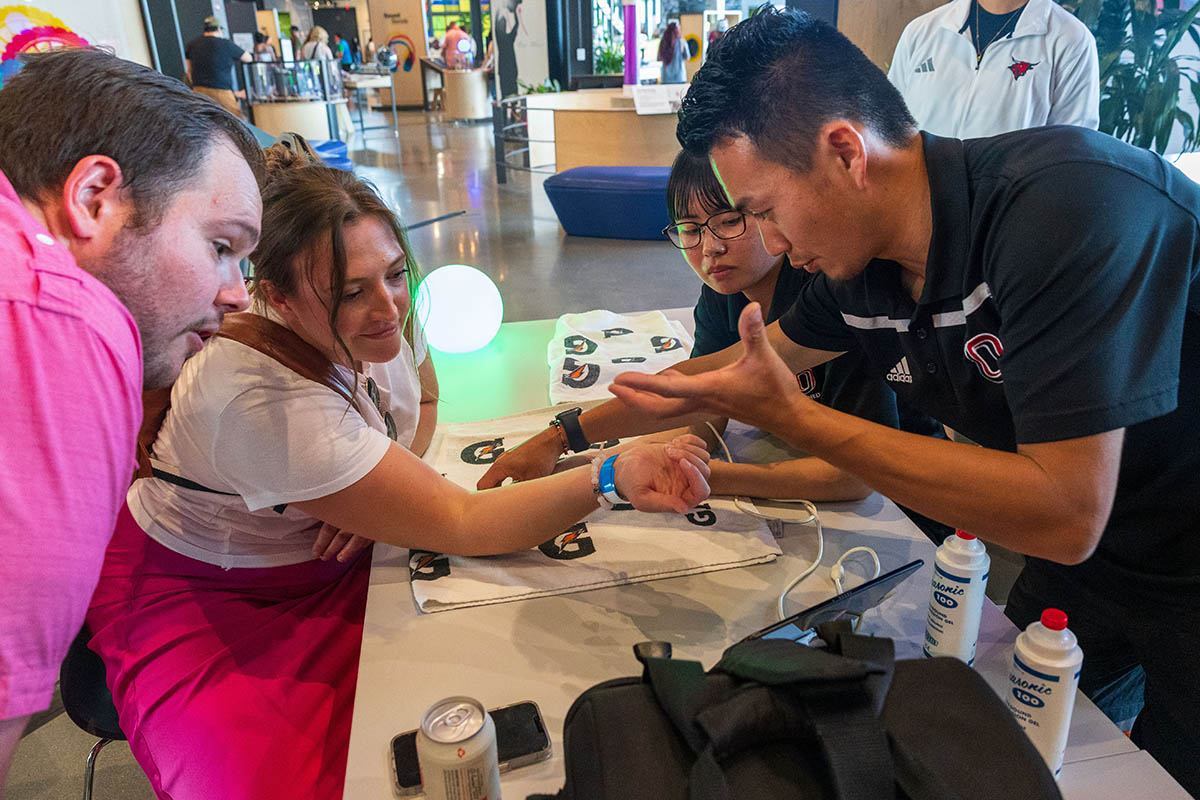 Two student researchers demo an ultrasound machine with two guests at the Luminarium 