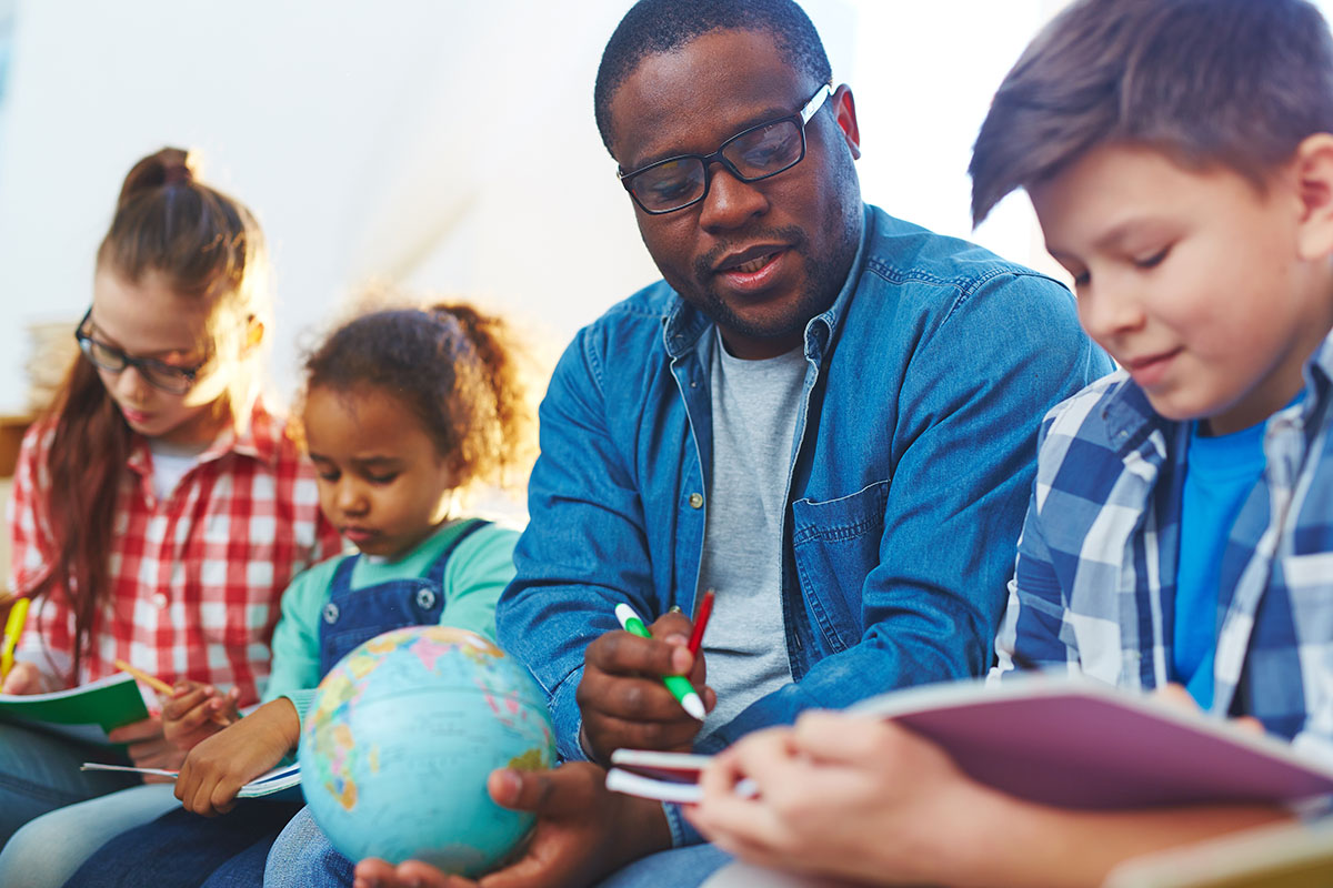 A teacher helps a child in a classroom