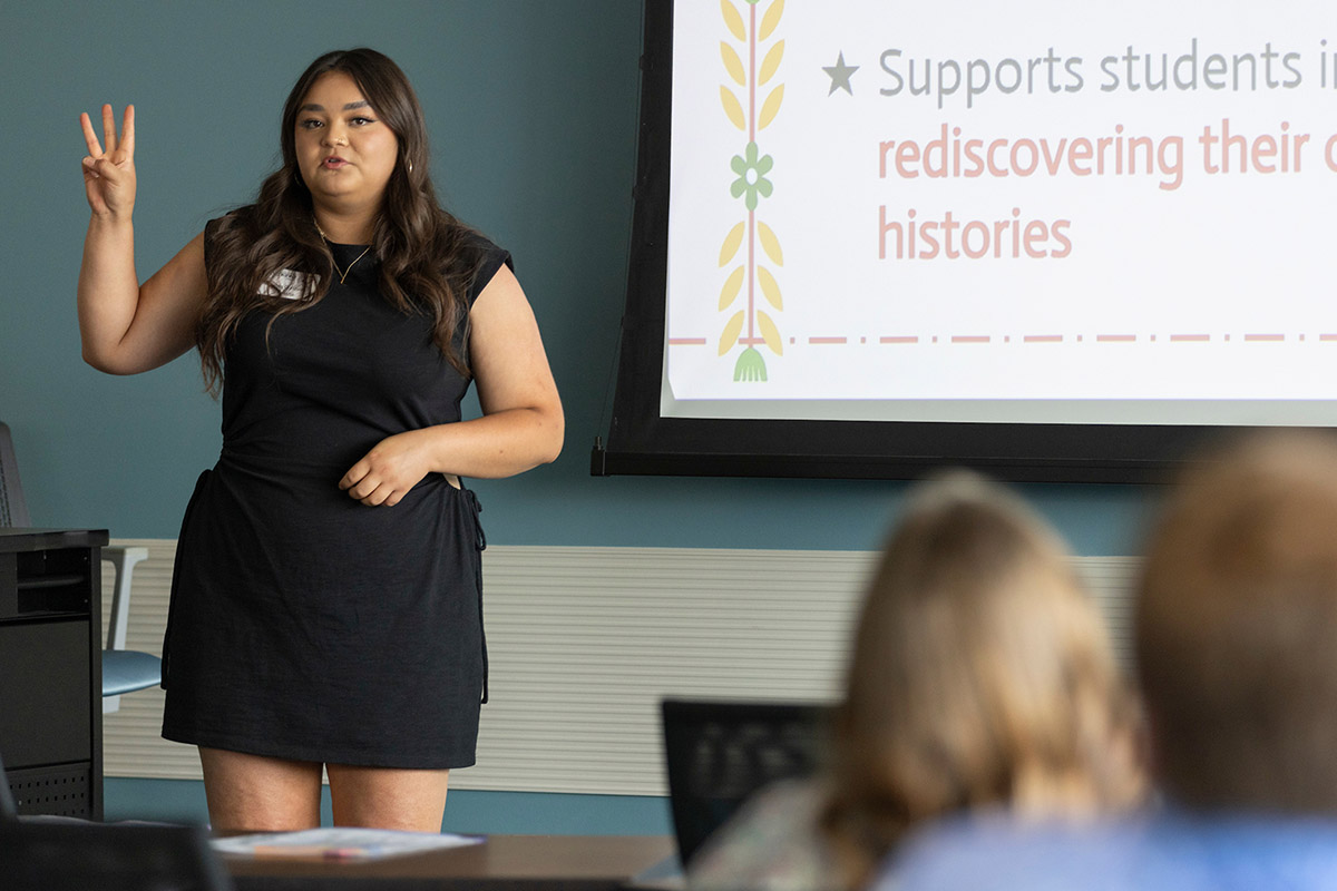 A teacher presents research in a conference room