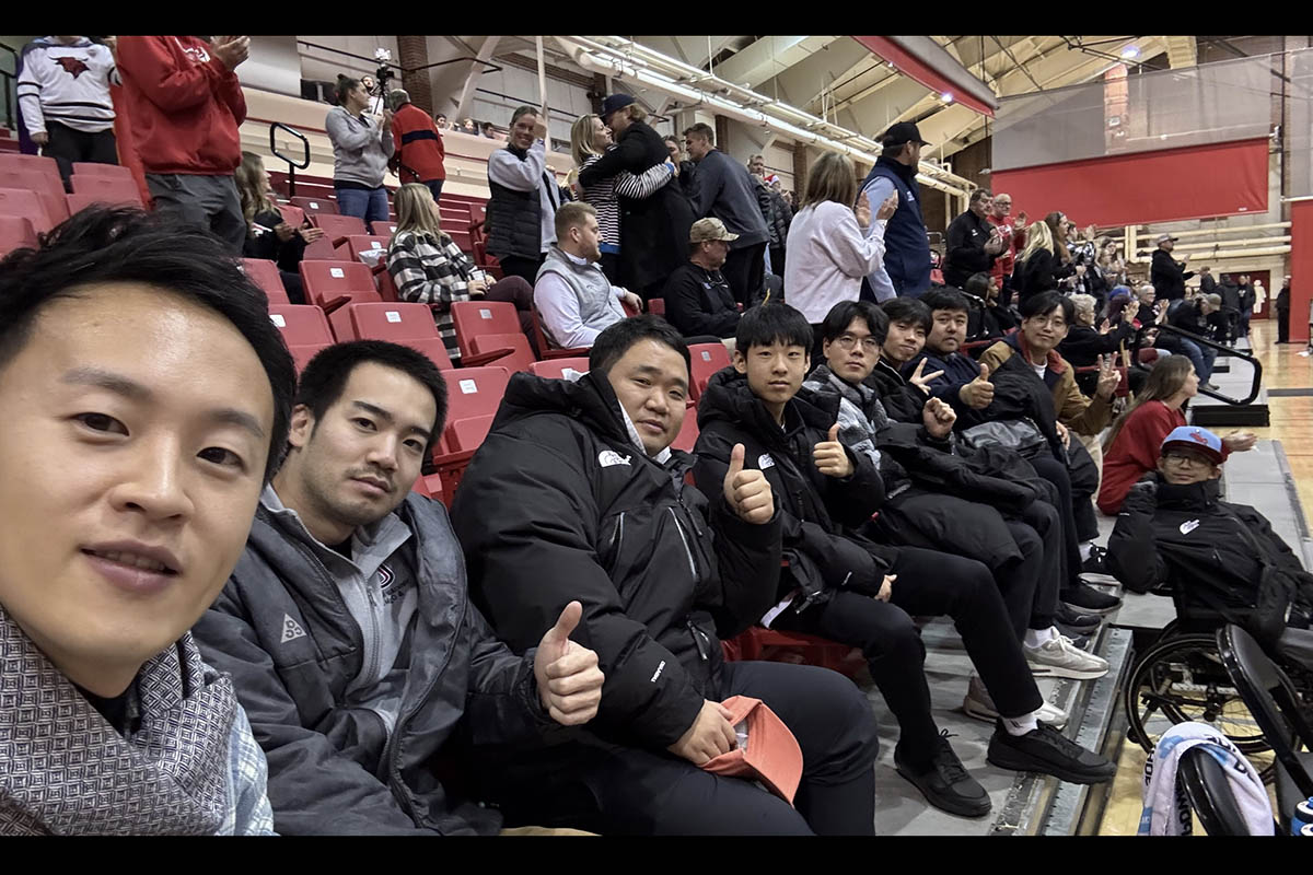 A group of people pose for a photo at a UNO basketball game