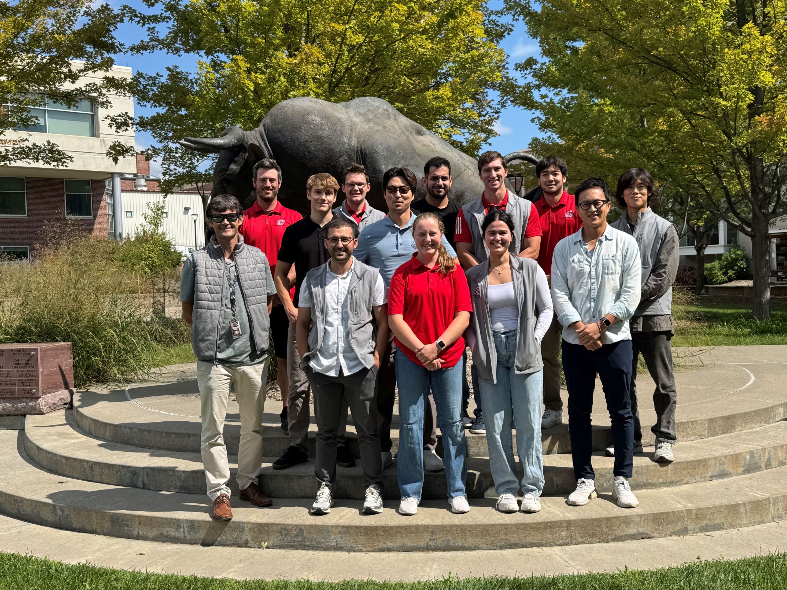 A group of people stand in front of the H&K Building