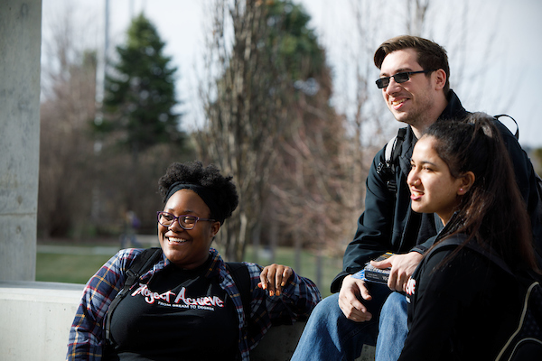 smiling students sitting on campus