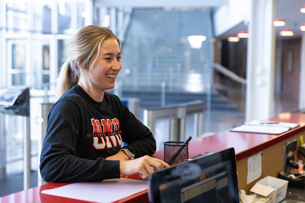 woman smiling as she stands at a counter