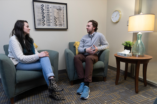 a man and woman sit in chars and talk