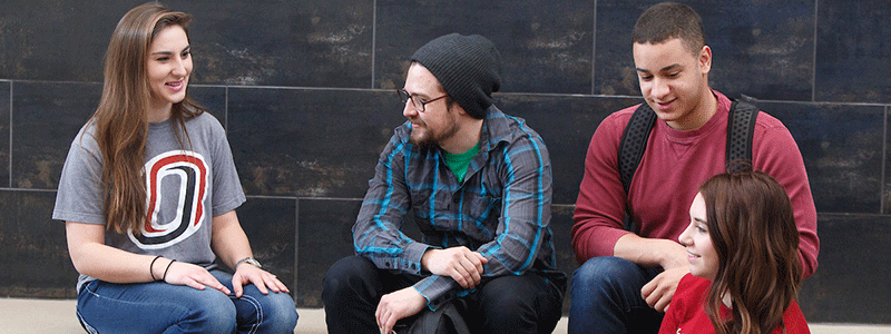 a group of students sit on a bench talking