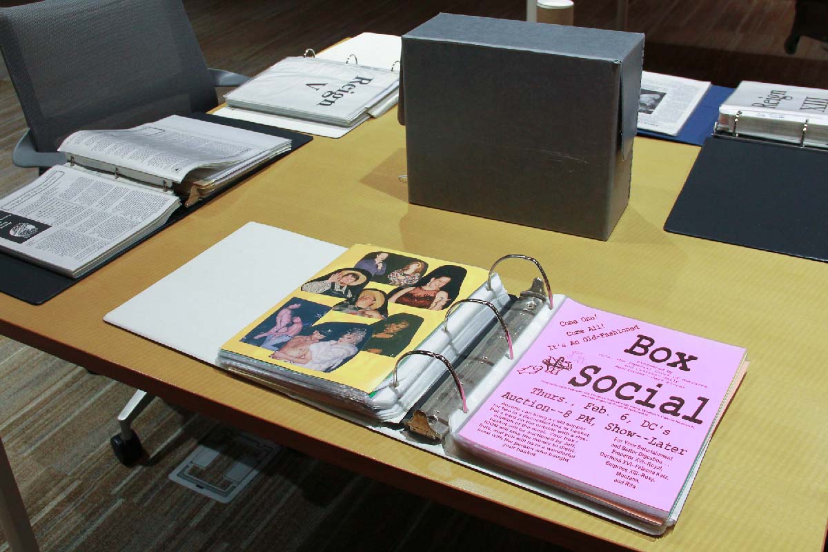 an open binder on a table with other open binders and file boxes 