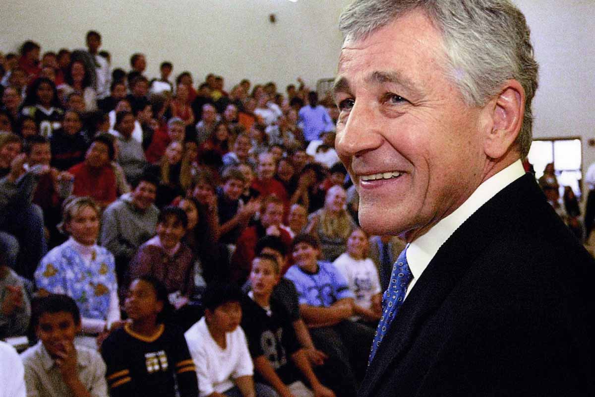 a man speaking to an assembly hall of middle school students 