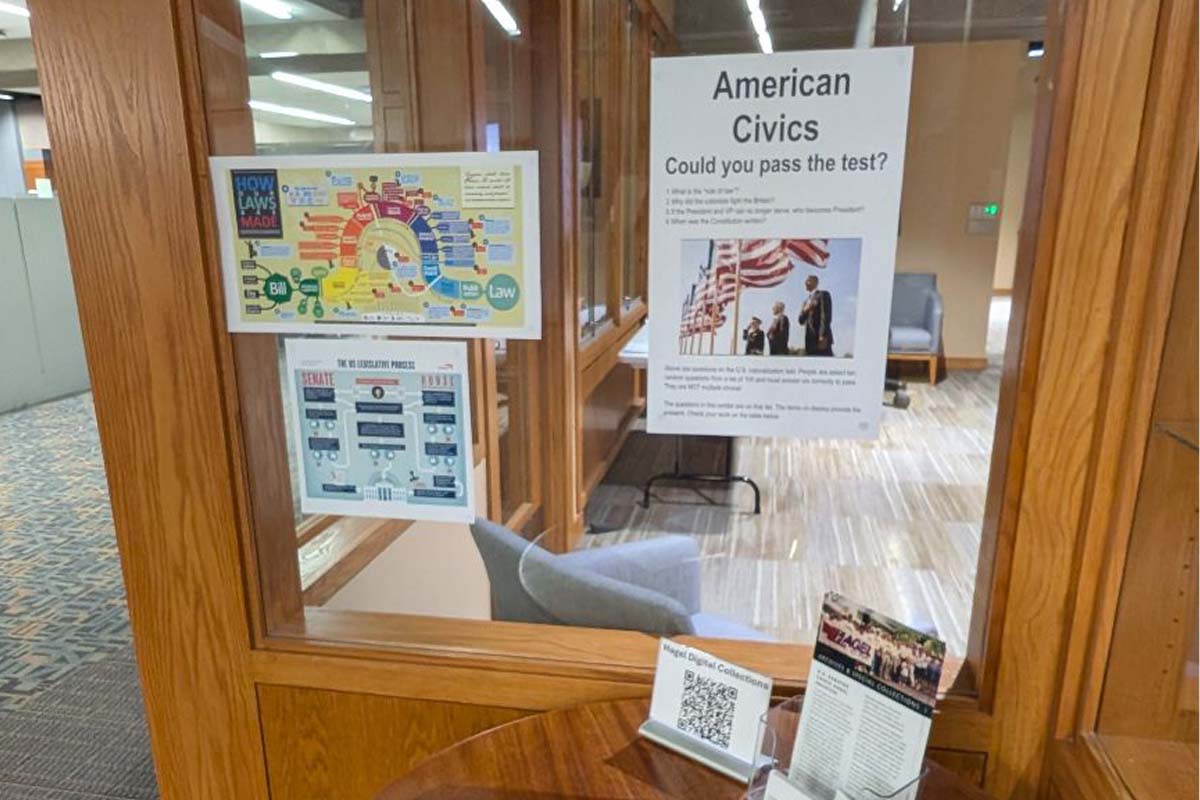 two posters hanging on a glass wall with information about the american civics test