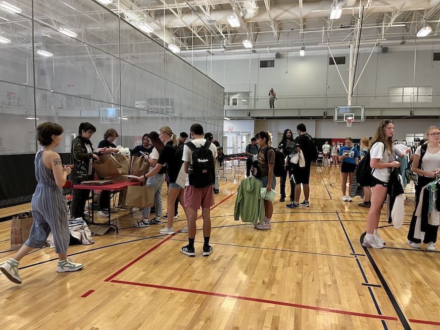 Many students in a gym with Durango's Outfitters clothing, shopping, and checking out