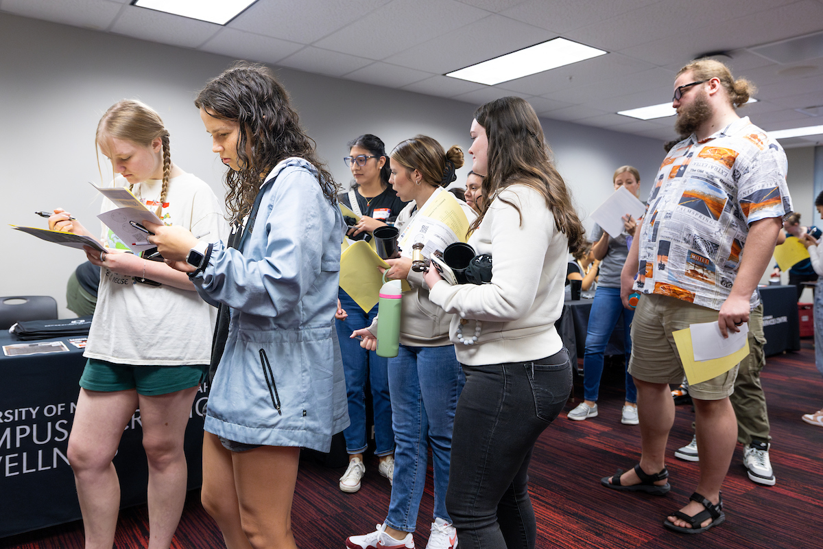 students holding papers and waiting in a line for Scholarship Welcome Day!