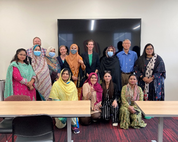 a group stands together in a meeting room in front of a TV