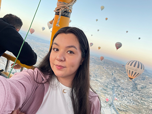 a young woman is in a hot air balloon in the air.