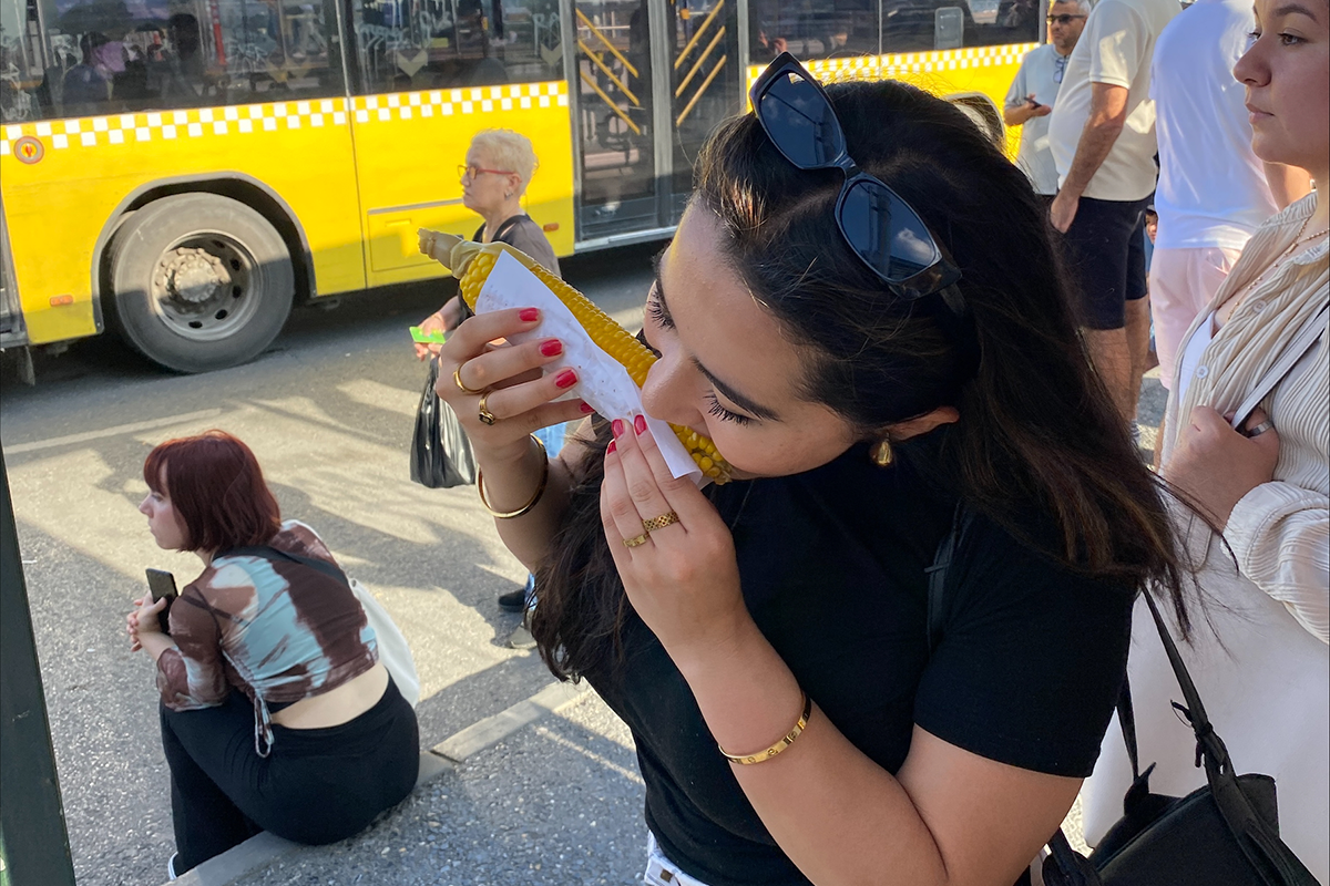 Young woman eating an ear of corn