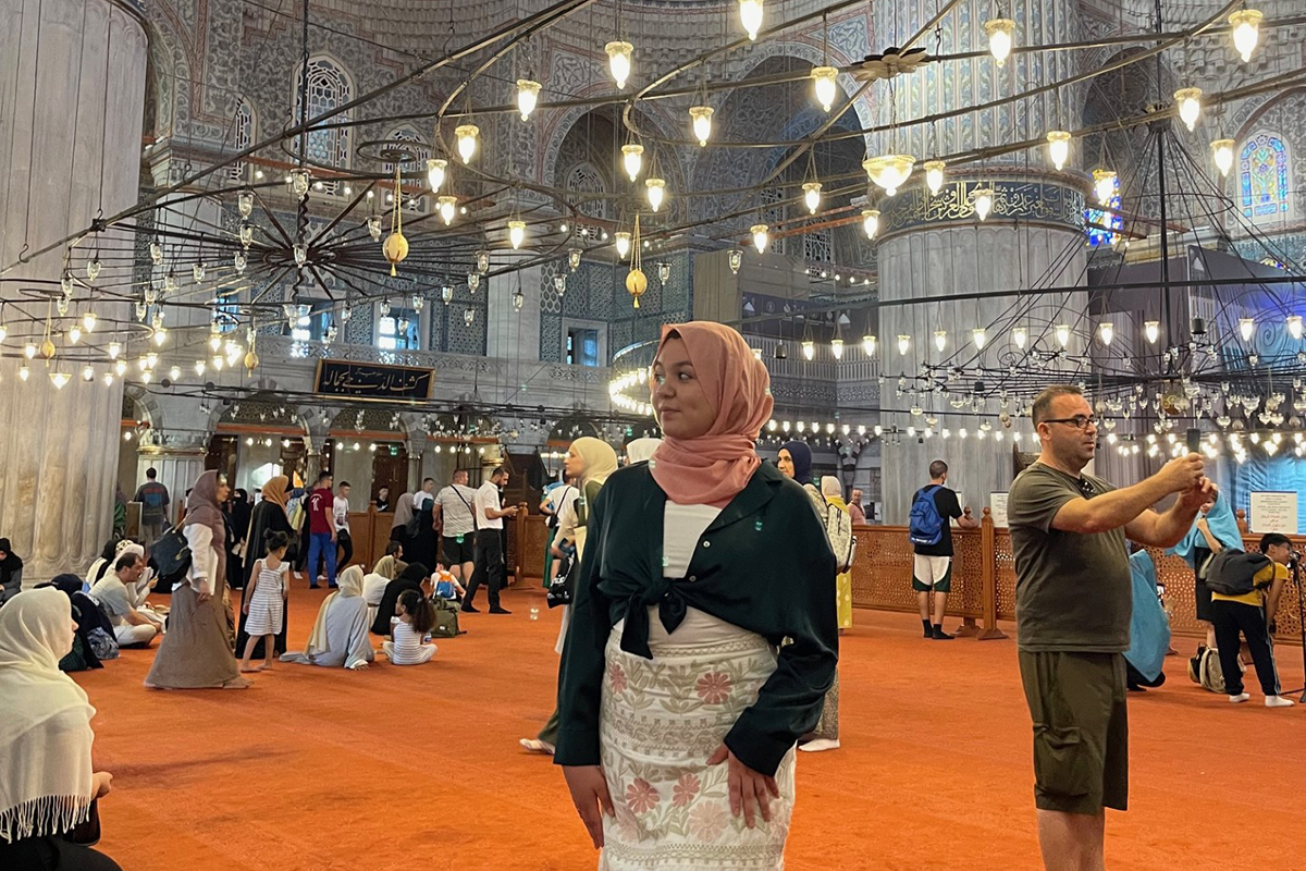 Young woman stands inside a mosque