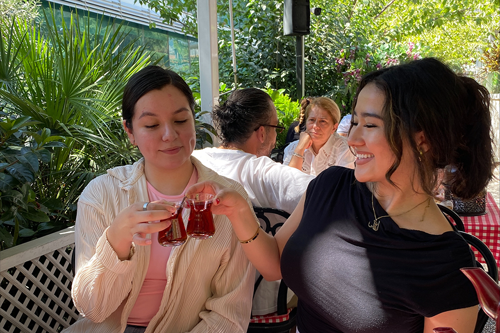 Two young woman drink tea together.