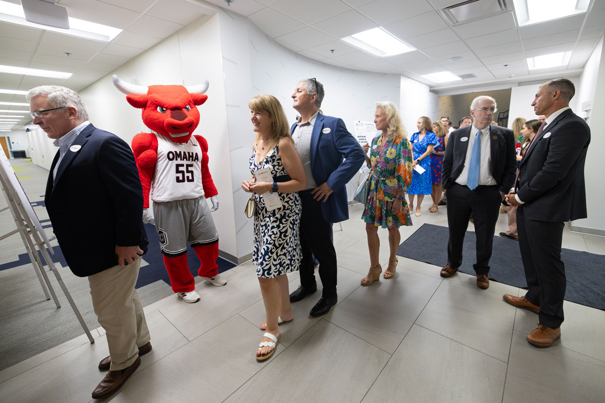A wide shot of the UNO mascot, Durango (a red bull) greeting guests as they file past.