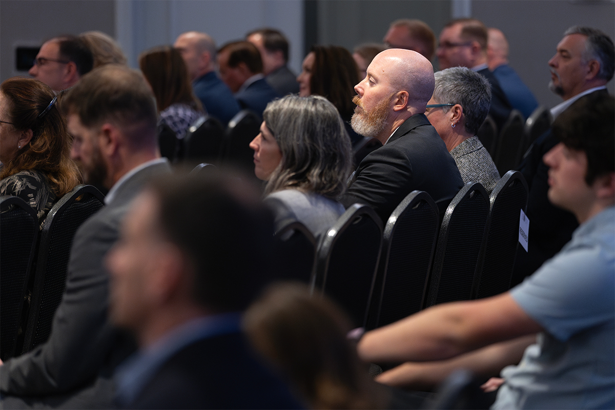 Individuals within audience watching Jen Easterly present.