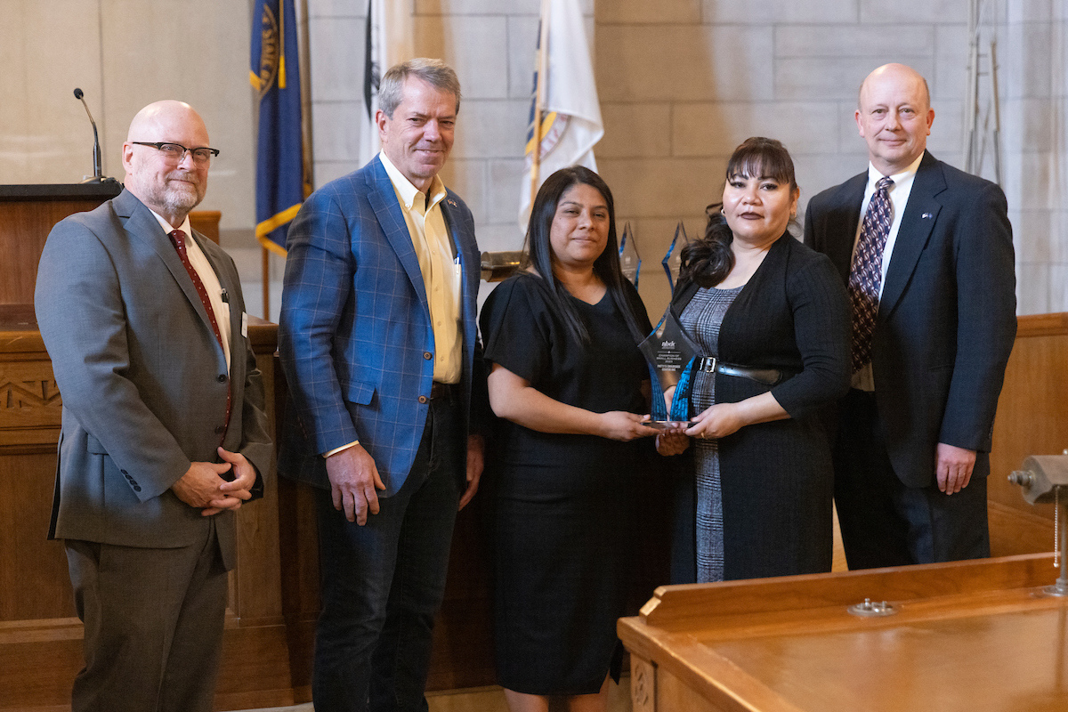 Avalos, joined by Alejandra Lopez, receives her award from Governor Jim Pillen, Nebraska Department of Economic Development Director K.C., Belitz, and NBDC Executive Director Dan Curran