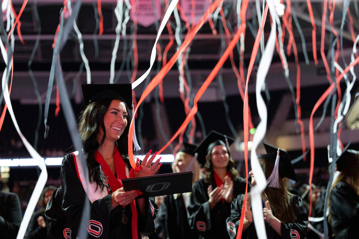 graduates celebrating as ribbons fall at commencement