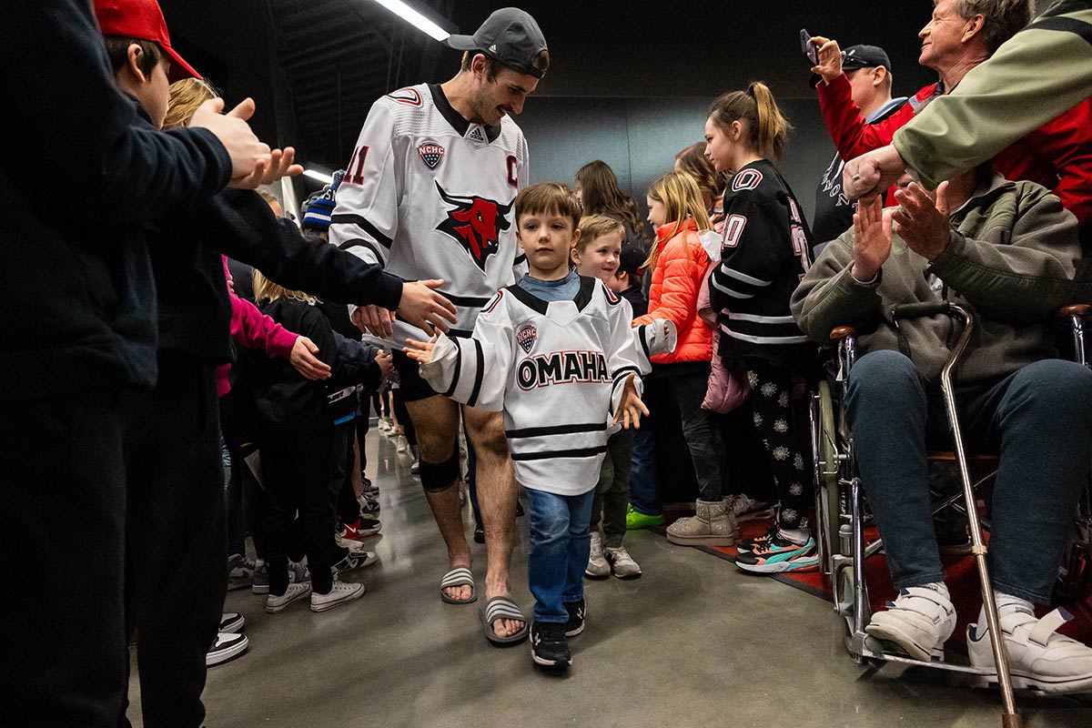 Sullivan celebrates with fans in the Baxter Arena atrium following a victory over Colorado College.