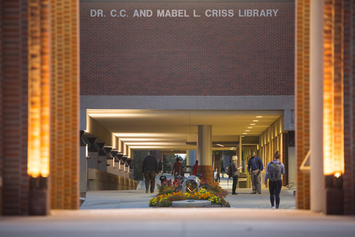 Students walking toward Criss Library at night