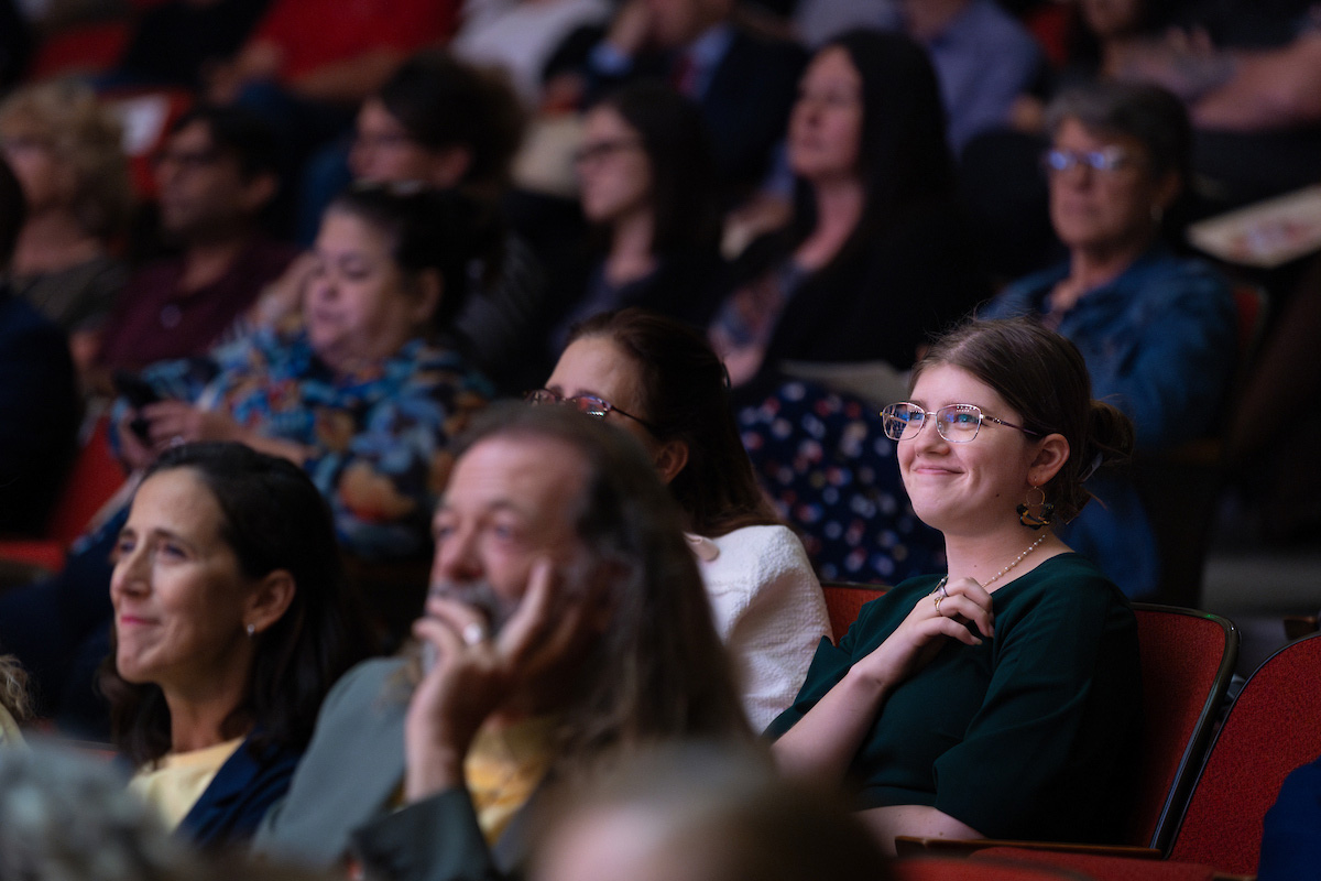 Individuals smiling while watching the address.