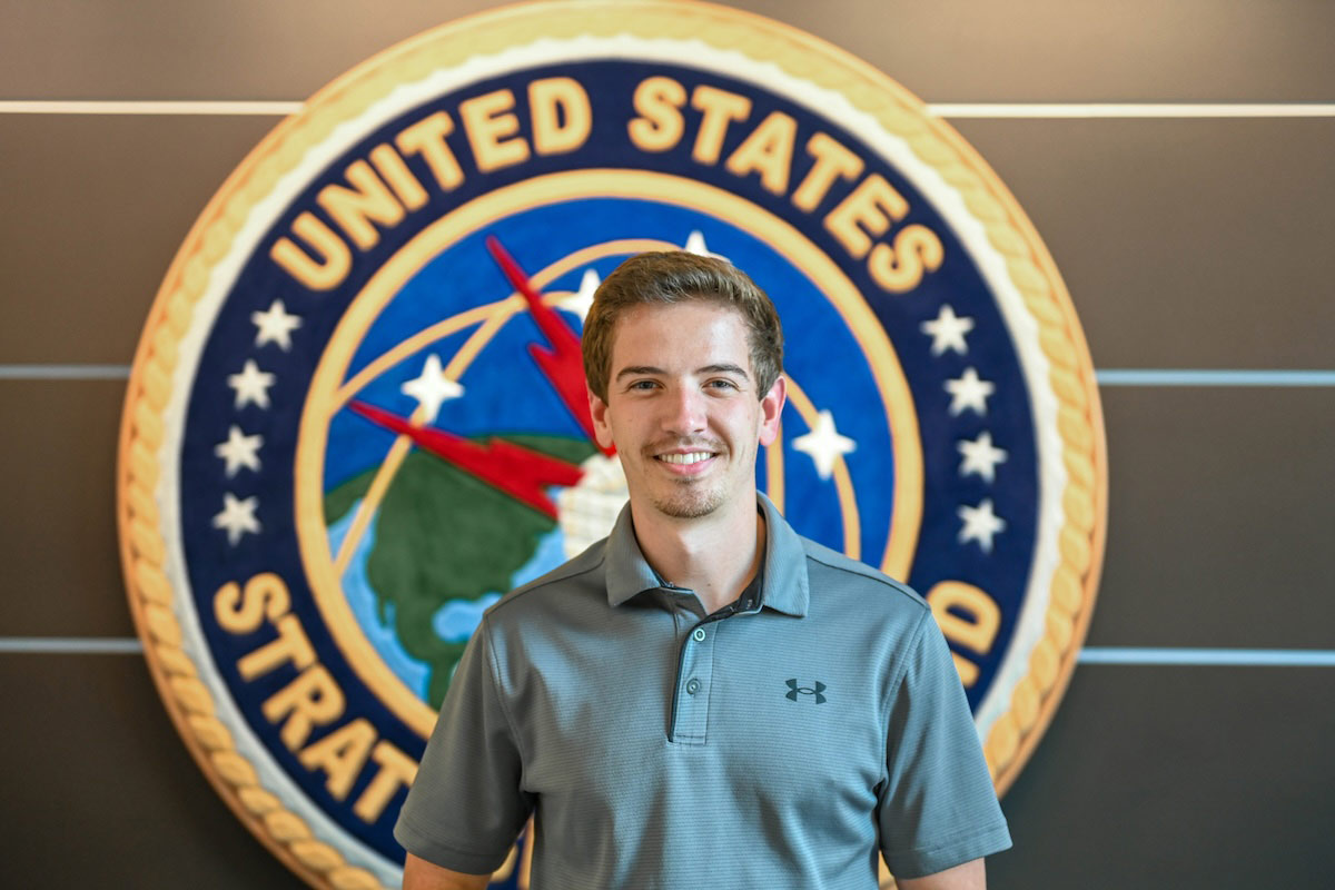 UNO senior, Blaine Nicola, stands in front of the Official Emblem U.S. Strategic Command Center located at Ofutt Airforce Base. 