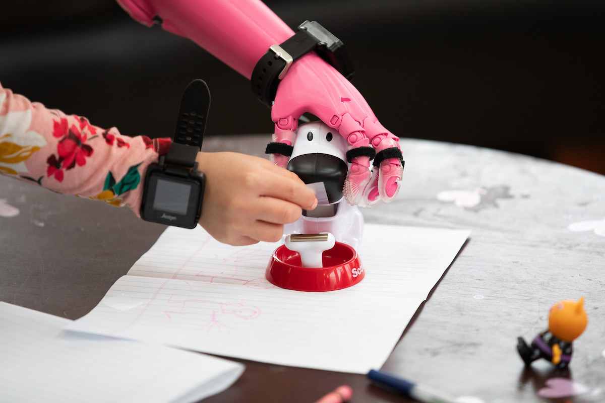 Rue Gillespie uses her prosthesis as she gets tape from a tape dispenser as University of Nebraska at Omaha (UNO) Biomechanics Professor Jorge M. Zuniga, Ph.D., and his team run Rue through a series of tests in January 2020, in Omaha, Nebraska, at the Gillespie home.