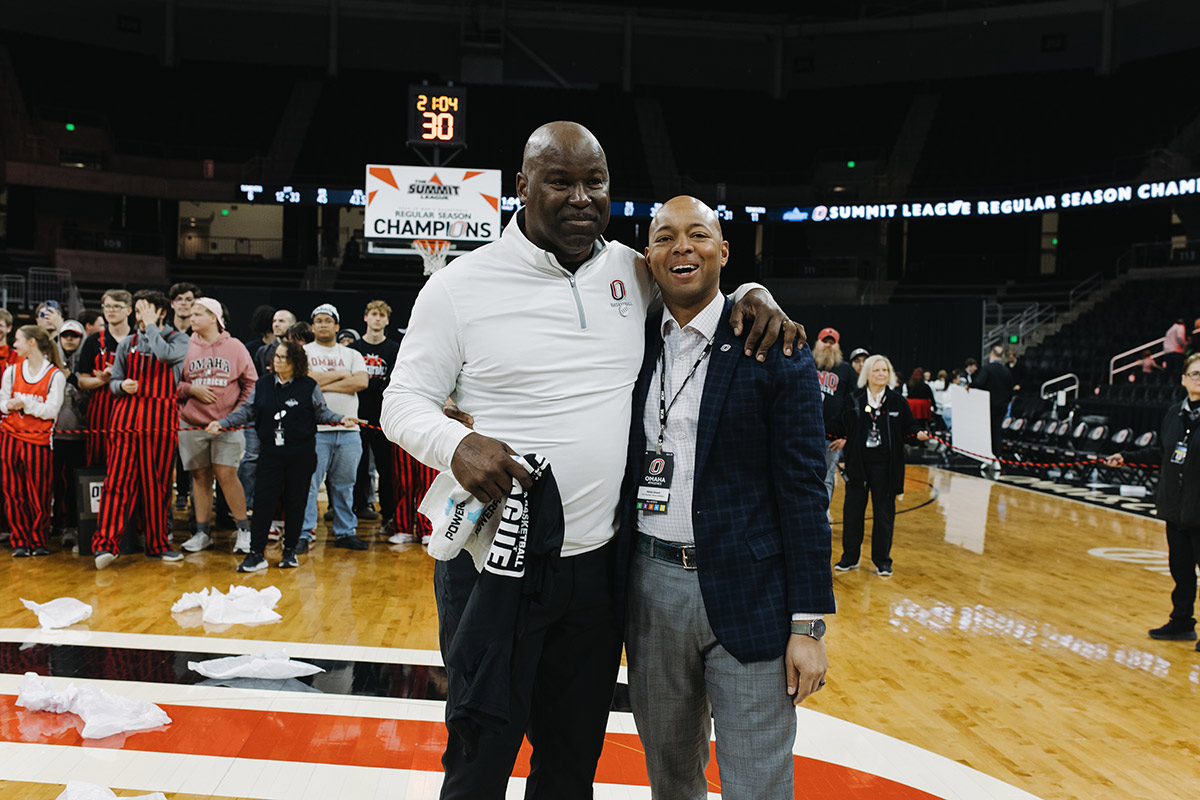 Omaha Men's Basketball head coach Chris Crutchfield and Vice Chancellor / Director of Athletics Adrian Dowell celebrate after the game.