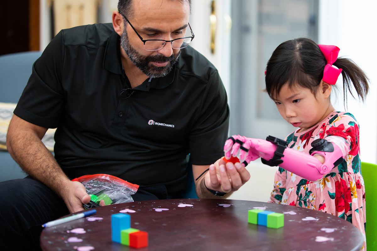 With the guidance of Jorge Zuniga, Ph.D., Rue Gillespie, 4, uses a prosthetic arm 3D-printed at UNO to complete exercises that require precise movements.