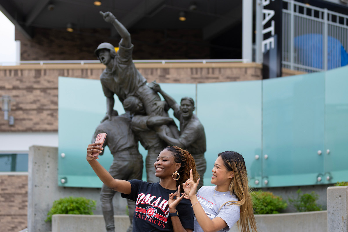 Maverick student ambassadors stand near the Road to Omaha statue.