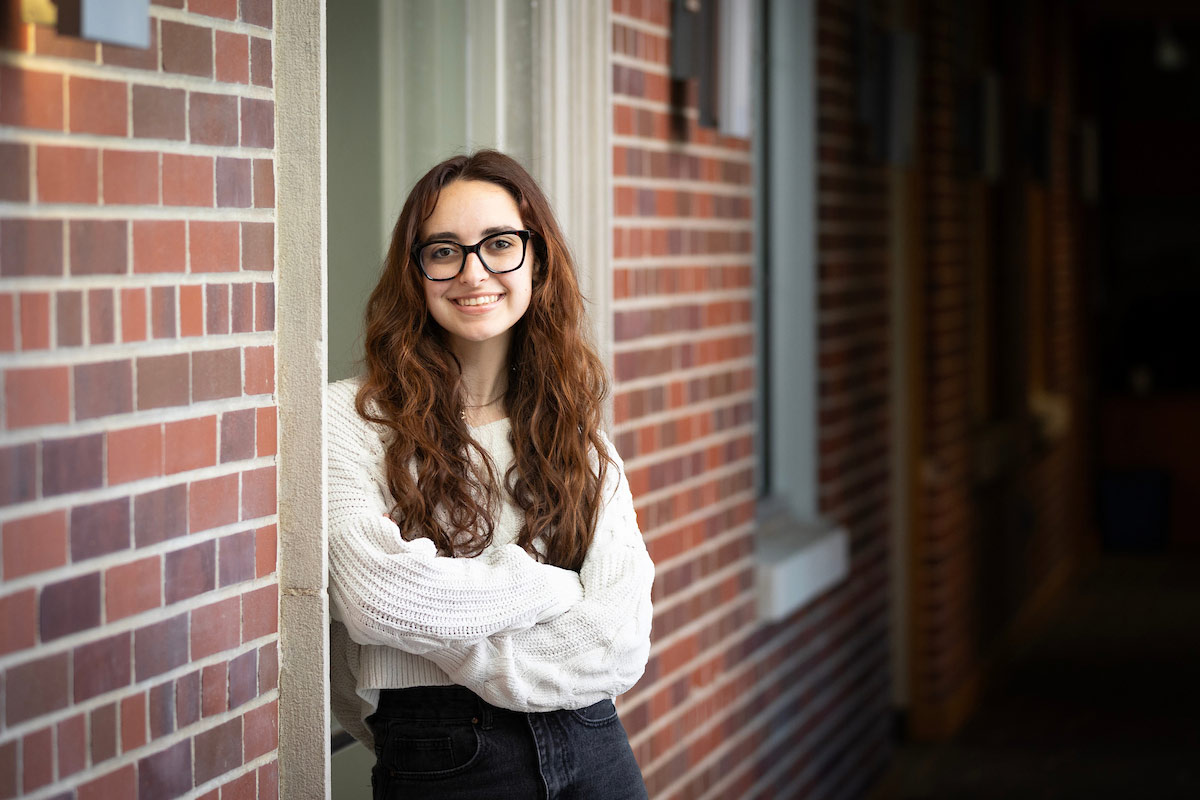 UNO graduate student Aislyn Tyler poses in front of UNO's College of Public Affairs and Community Service.