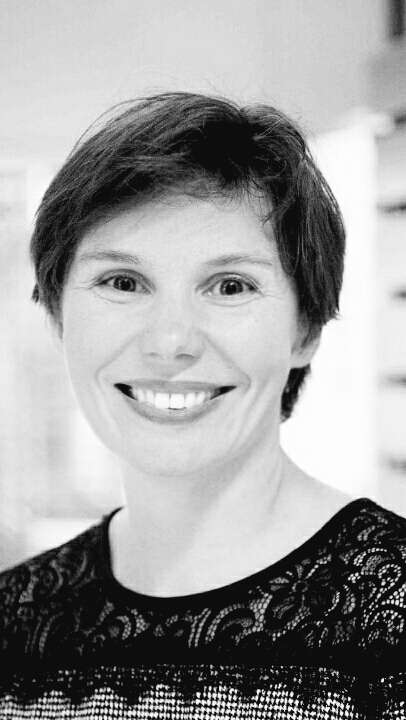 a black and white photo of a woman with short hair smiling at the camera