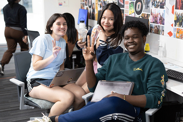 students in an office smiling and laughing for the camera